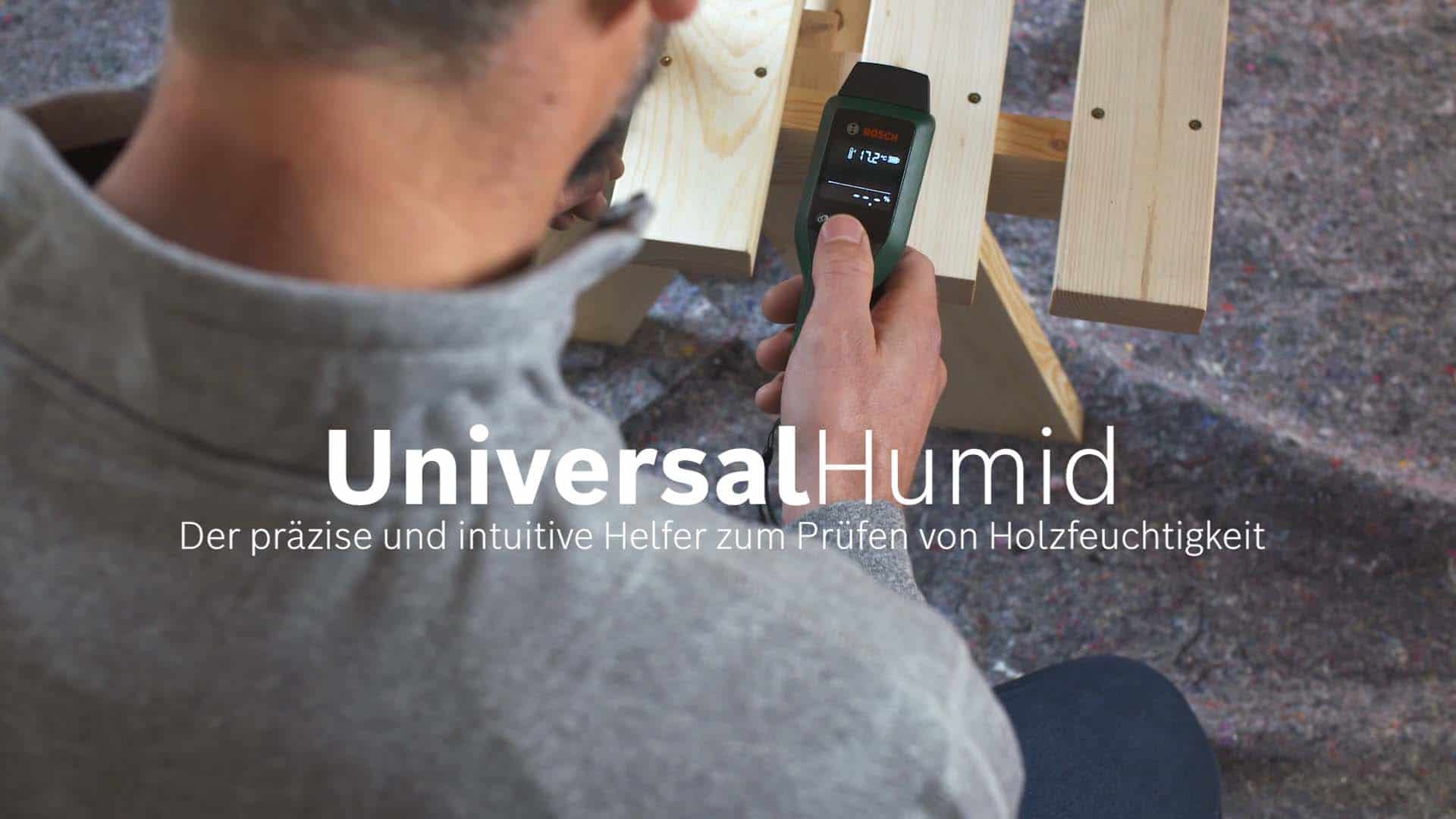 Darsteller prüft mit dem Universal Hamid Tool von Bosch die Holzfeuchtigkeit.